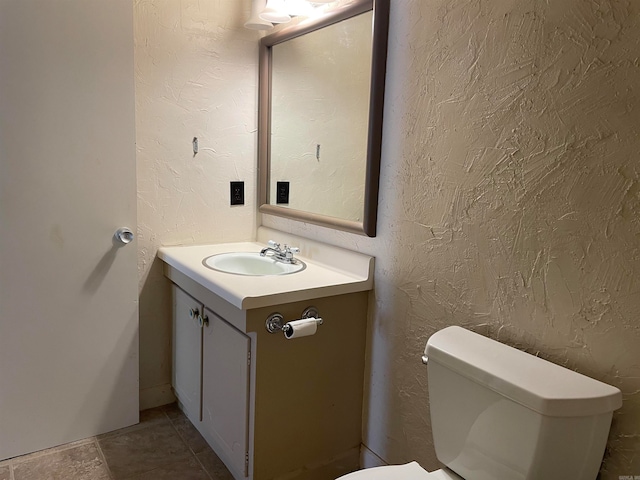 bathroom with tile patterned flooring, vanity, and toilet