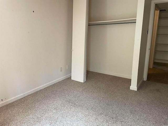 unfurnished bedroom with a closet and carpet flooring