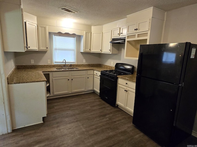 kitchen featuring a textured ceiling, black appliances, sink, and dark hardwood / wood-style floors