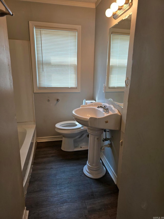 bathroom with crown molding, toilet, hardwood / wood-style flooring, and plus walk in shower