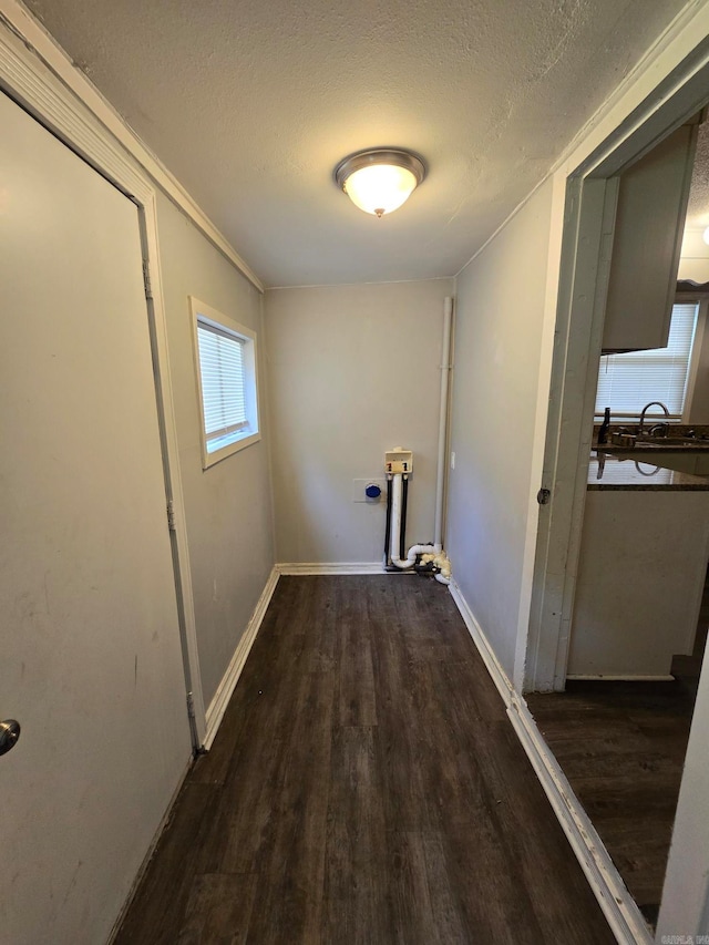 corridor featuring dark hardwood / wood-style floors, crown molding, and a textured ceiling