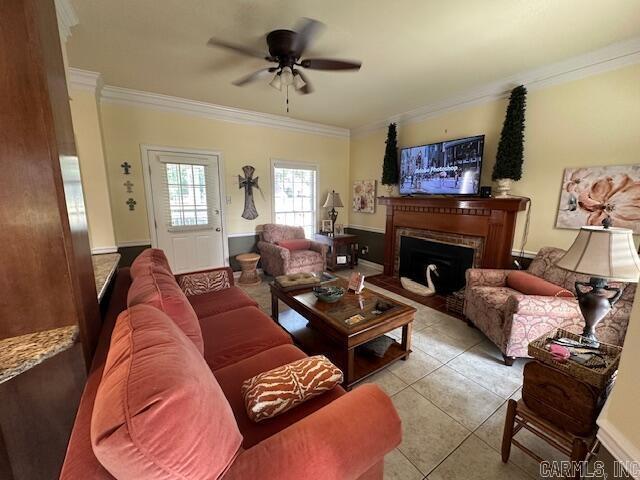 living room featuring tile patterned floors, a fireplace, a ceiling fan, and ornamental molding