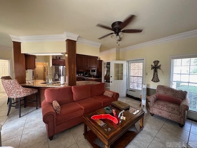 tiled living room featuring ceiling fan, ornamental molding, and sink