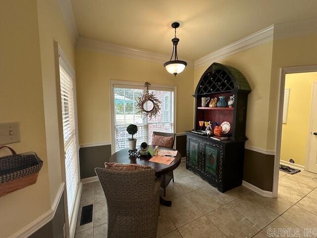 dining area featuring light tile patterned floors, visible vents, baseboards, and crown molding