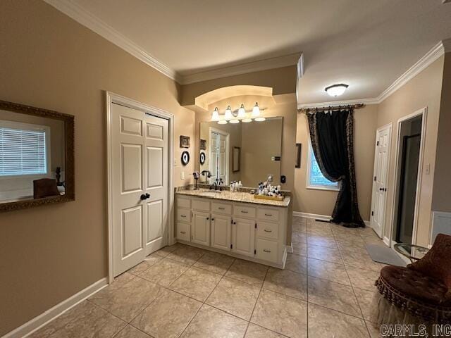 bathroom with vanity, crown molding, baseboards, and tile patterned flooring