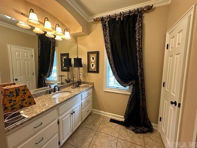 bathroom featuring crown molding, vanity, a healthy amount of sunlight, and tile patterned flooring