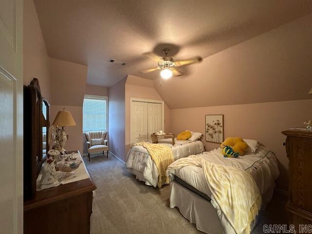 bedroom with visible vents, ceiling fan, carpet, lofted ceiling, and a closet