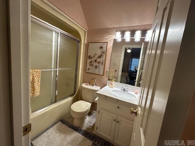 full bathroom with vanity, vaulted ceiling, bath / shower combo with glass door, tile patterned flooring, and toilet