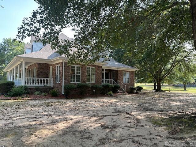 view of side of home with brick siding and a porch