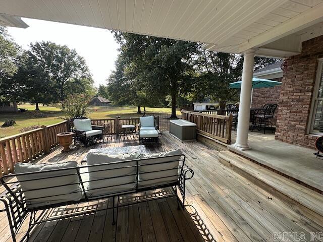 wooden terrace with an outdoor living space