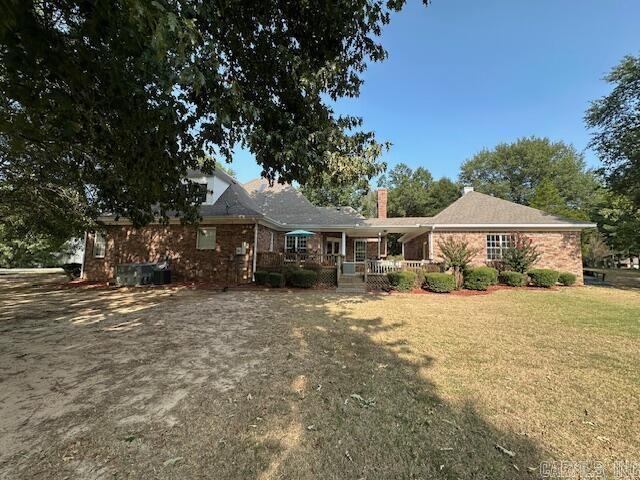 rear view of property with a yard and brick siding