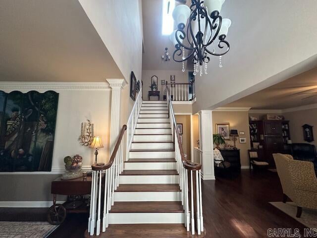 stairway featuring hardwood / wood-style flooring, a chandelier, and a high ceiling