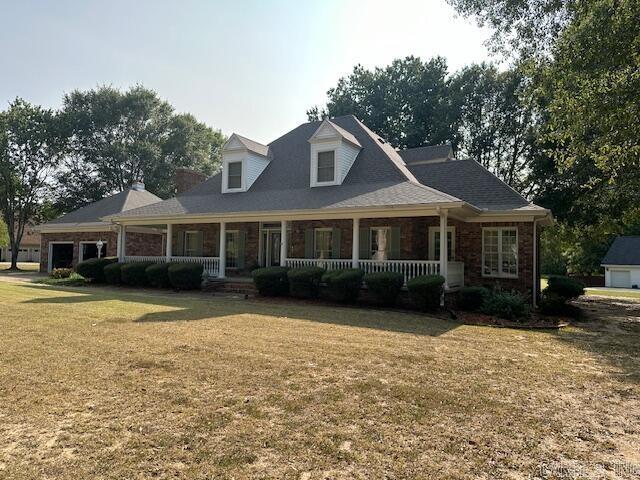 view of front of home featuring covered porch and a front yard