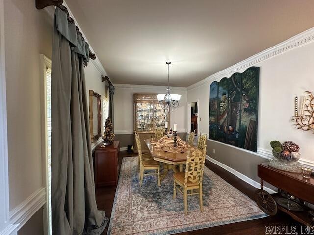 dining space featuring dark wood-style floors, baseboards, an inviting chandelier, and ornamental molding