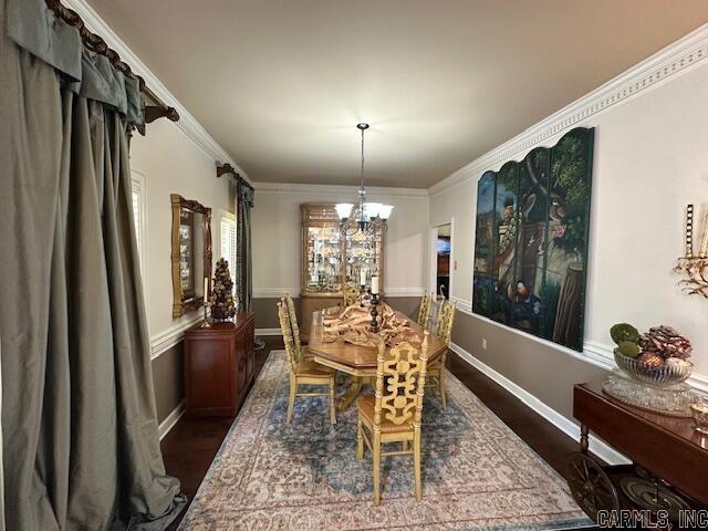 dining space with crown molding, dark hardwood / wood-style flooring, and a chandelier