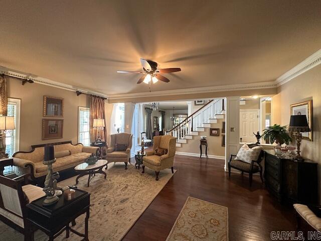 living room featuring crown molding, stairway, baseboards, and dark wood-style flooring