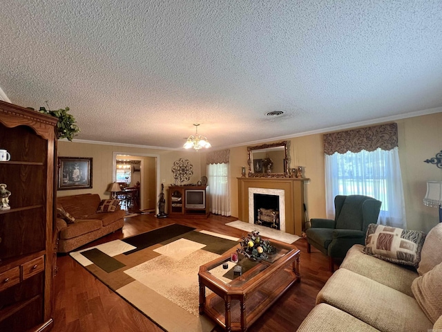 living area featuring ornamental molding, wood finished floors, a fireplace with flush hearth, and a chandelier