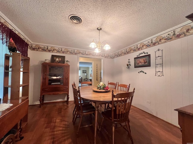dining room with visible vents, crown molding, a chandelier, dark wood-style floors, and a textured ceiling