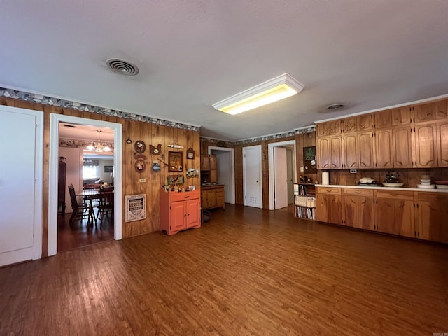 kitchen featuring visible vents, a notable chandelier, heating unit, dark wood finished floors, and light countertops