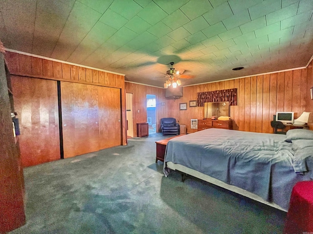 carpeted bedroom with wood walls, crown molding, and ceiling fan