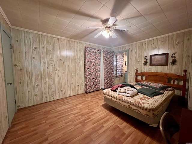 bedroom with wood finished floors, a ceiling fan, and ornamental molding