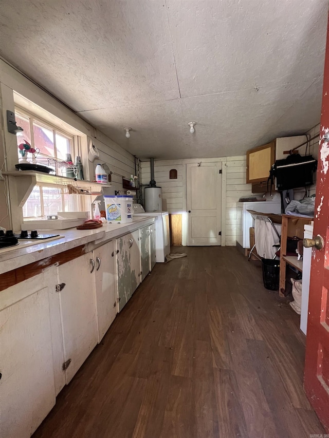 kitchen with white cabinets, dark wood-style flooring, water heater, and a textured ceiling