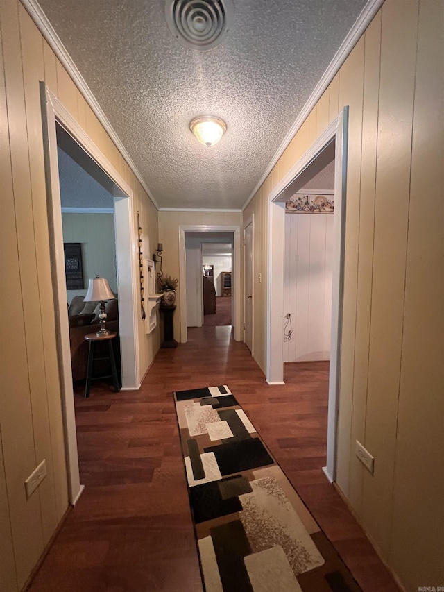 corridor featuring visible vents, wood finished floors, and crown molding