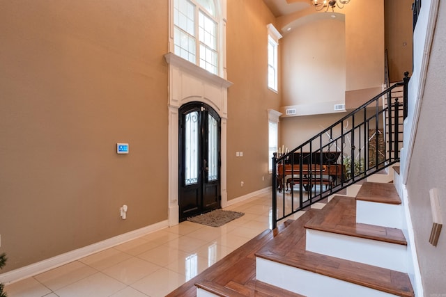 entryway with a high ceiling and light tile patterned floors