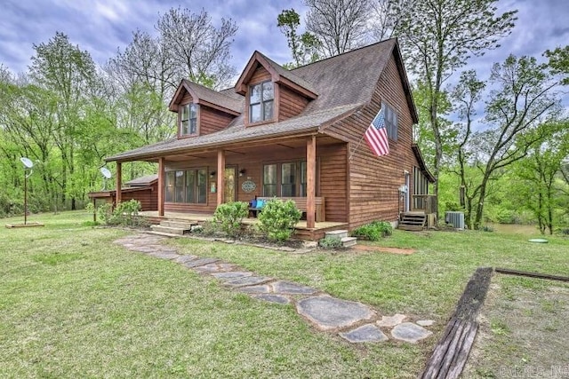 chalet / cabin featuring central AC unit, entry steps, and a front lawn