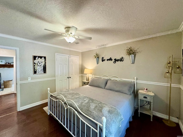 bedroom with a textured ceiling, dark hardwood / wood-style flooring, a closet, ceiling fan, and ornamental molding