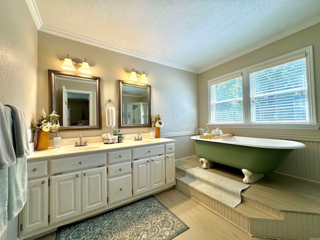 bathroom with a tub, ornamental molding, vanity, a textured ceiling, and wood-type flooring