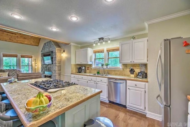 kitchen featuring a textured ceiling, appliances with stainless steel finishes, sink, white cabinetry, and light wood-type flooring