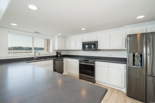 kitchen with white cabinets, light wood-type flooring, stainless steel appliances, and sink