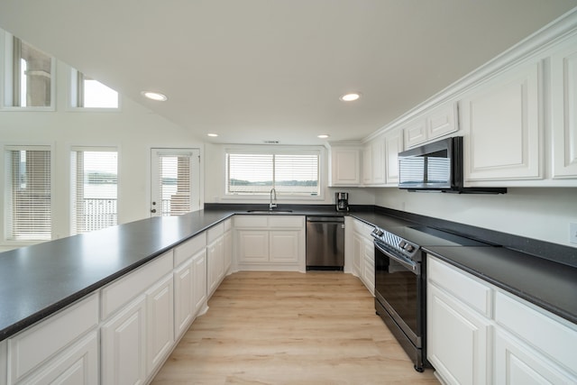 kitchen featuring appliances with stainless steel finishes, sink, white cabinetry, and light hardwood / wood-style flooring