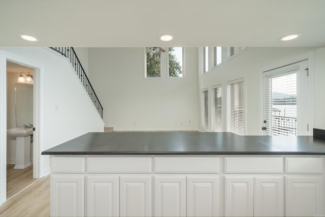 kitchen with a healthy amount of sunlight, white cabinetry, and light hardwood / wood-style floors