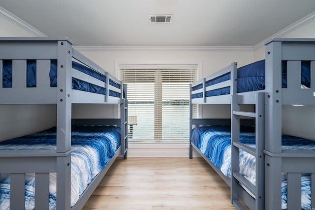 bedroom featuring crown molding and light hardwood / wood-style floors