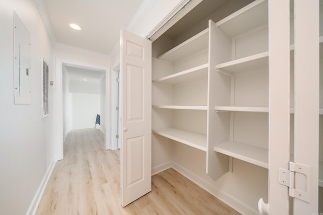 interior space with electric panel, light hardwood / wood-style floors, and ornamental molding