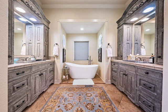 bathroom with tile patterned flooring, a tub, vanity, and crown molding