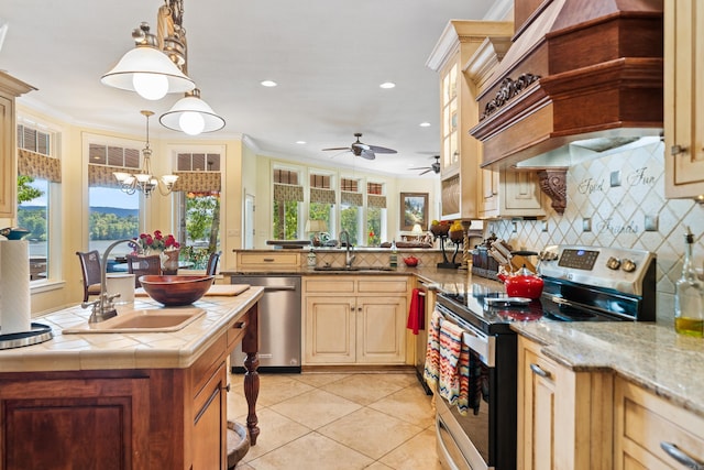 kitchen with ceiling fan with notable chandelier, kitchen peninsula, sink, hanging light fixtures, and appliances with stainless steel finishes