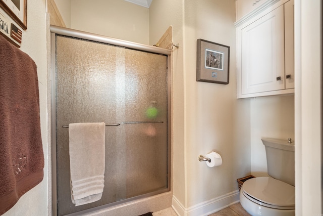 bathroom featuring toilet, an enclosed shower, and tile patterned floors