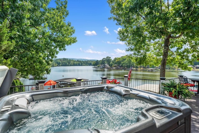 deck featuring a hot tub and a water view