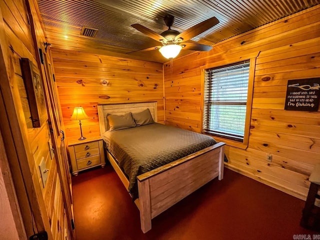 bedroom featuring ceiling fan and wooden walls