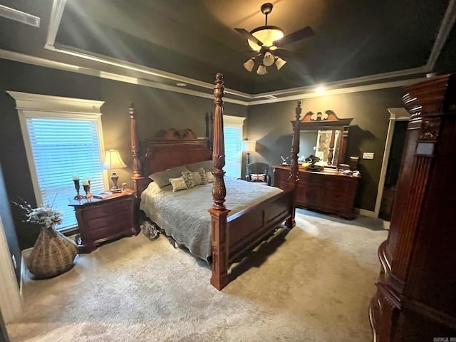 carpeted bedroom featuring crown molding, a tray ceiling, and ceiling fan