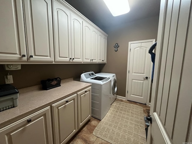 clothes washing area featuring light tile patterned floors, cabinets, and washing machine and clothes dryer