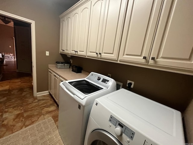 clothes washing area featuring washer and clothes dryer and cabinets