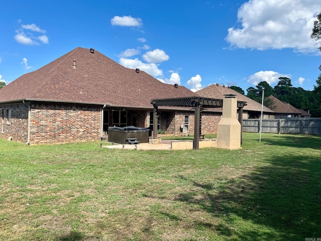 rear view of house with a patio, a hot tub, and a lawn