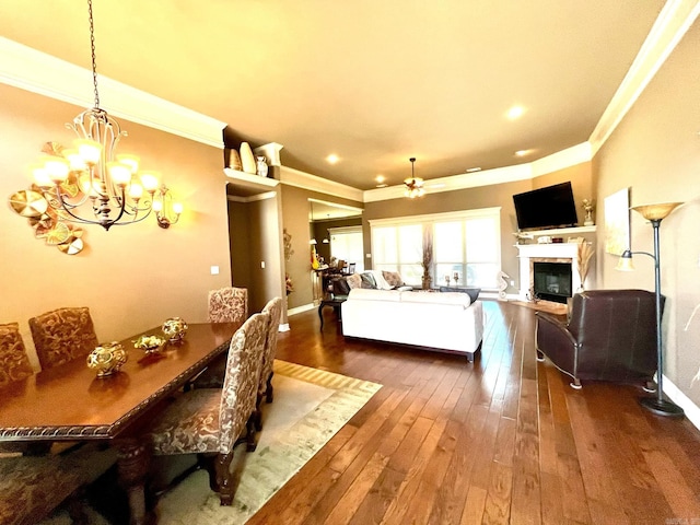 dining space featuring crown molding, ceiling fan with notable chandelier, and dark hardwood / wood-style flooring