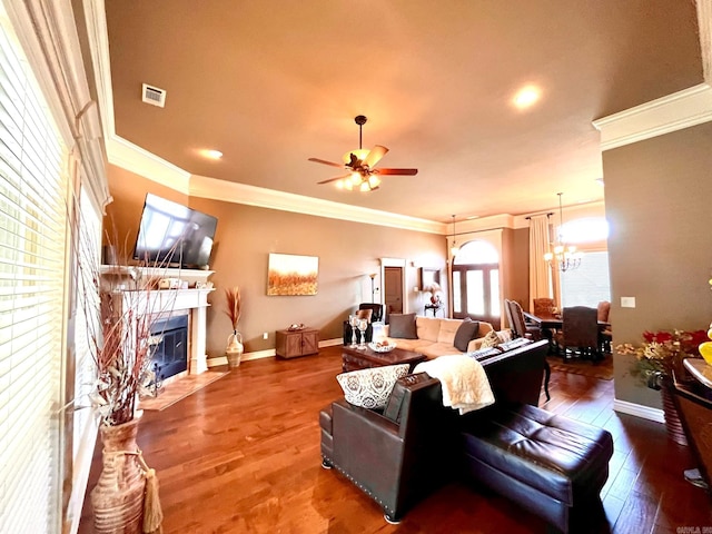 living room with ornamental molding, hardwood / wood-style flooring, and ceiling fan with notable chandelier