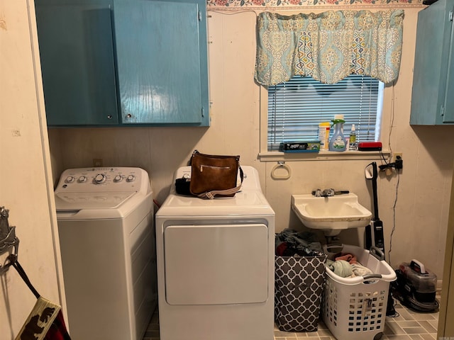 laundry room featuring cabinets, separate washer and dryer, and sink