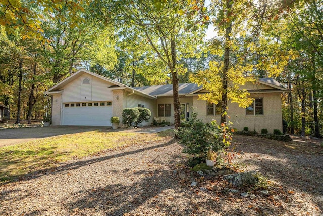 single story home featuring brick siding, an attached garage, and driveway